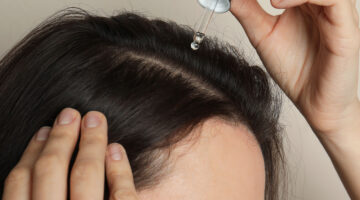 dark haired girl applying serum to scalp
