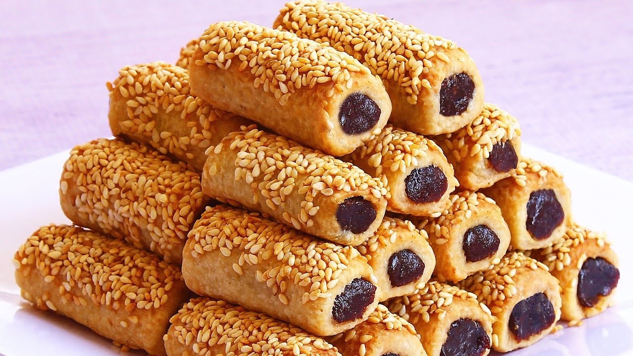 بطعم لا يقاوم.. طريقة عمل أصابع التمر بالسمسم على أصولها بعجينة مظبوطة أحلى من الجاهز