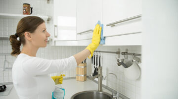 profile portrait attractive woman cleaning white kitchen clos