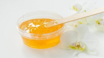 sugar paste wax honey transparent jar white orchid white background sugaring depilation beauty concept waxing beautiful background with orchids 132259 673 1